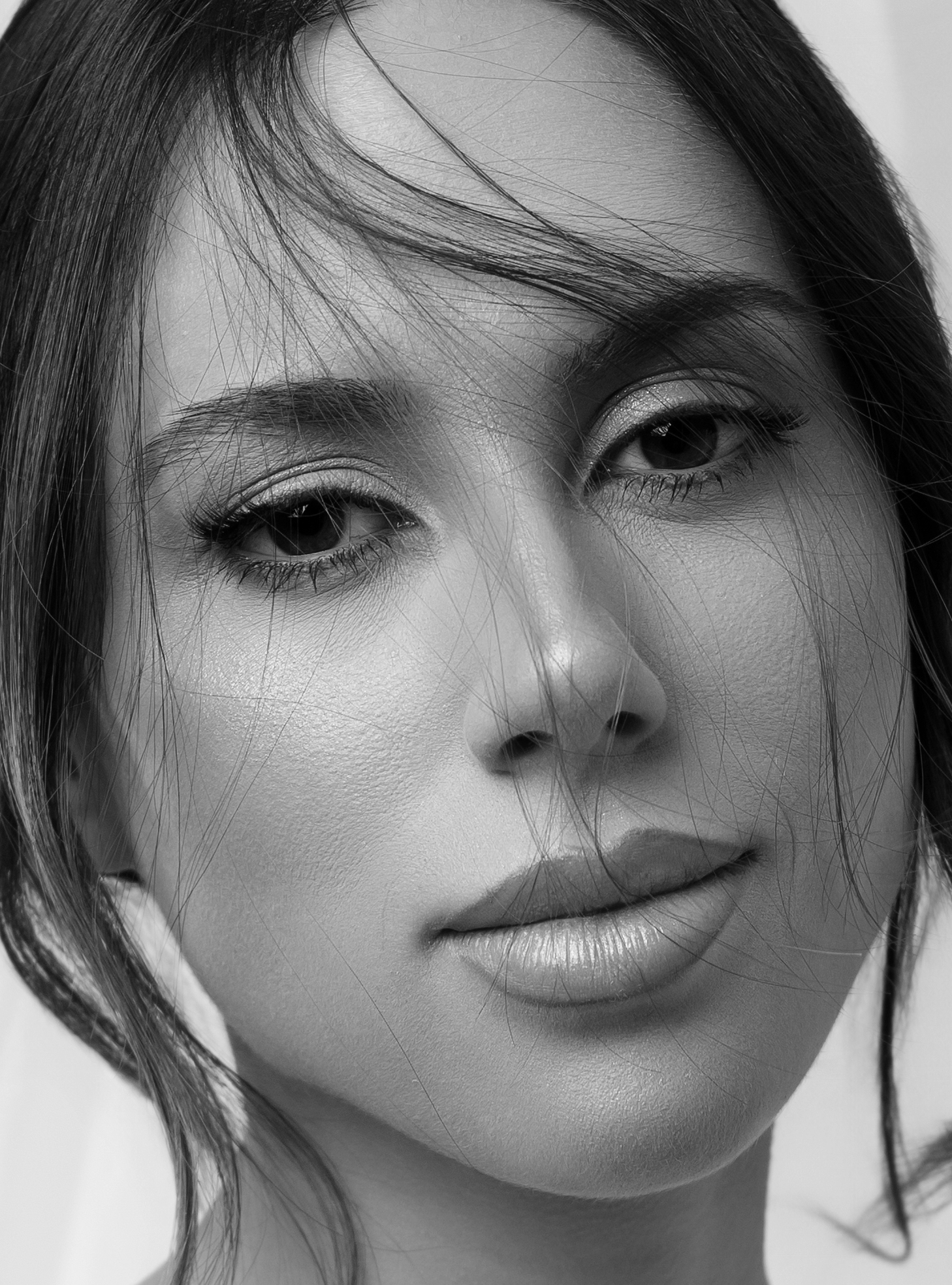Retrato em preto e branco de mulher em close, olhar direto para a câmera