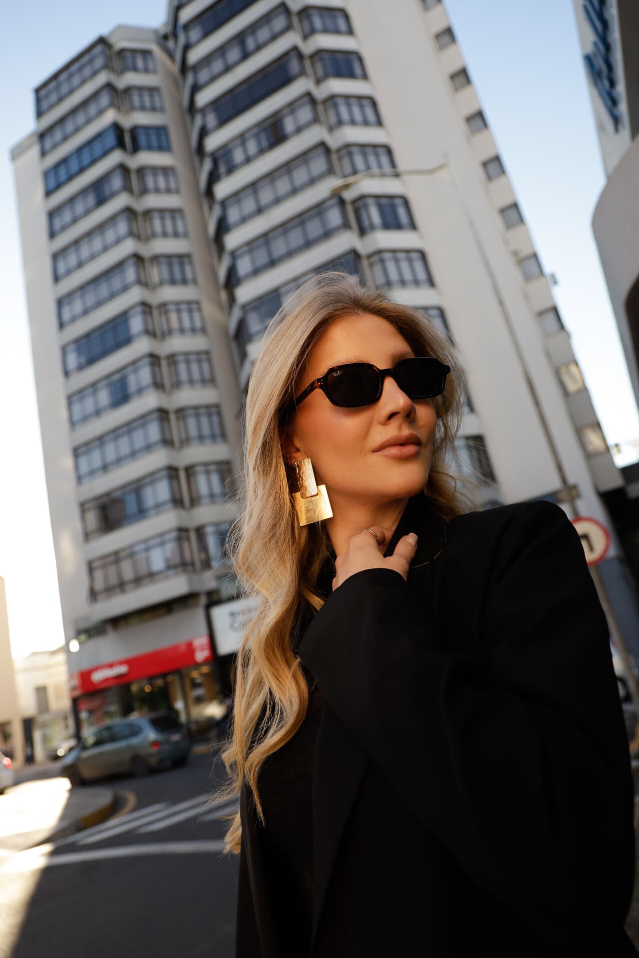 Retrato de mulher de óculos escuros na rua, no fim da tarde